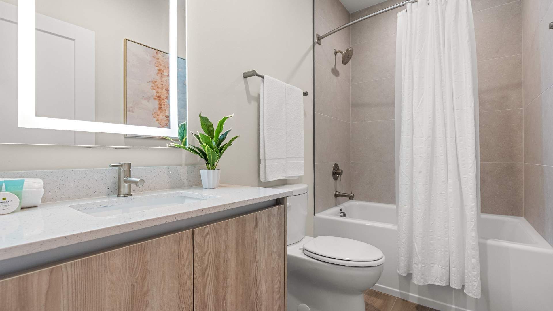 A modern bathroom with a sink, toilet, and bathtub.