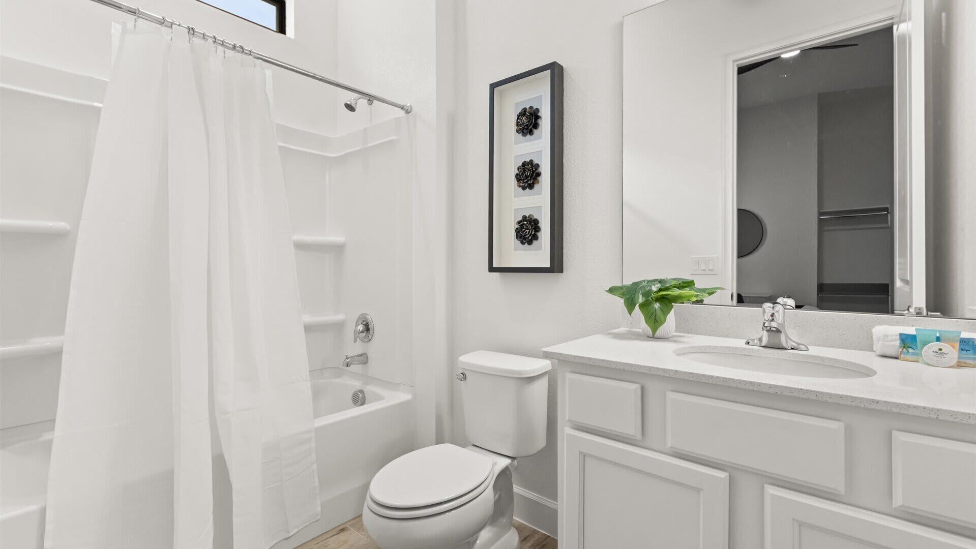 A modern bathroom with a shower, toilet, and sink.