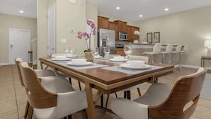 A dining area with a wooden table set for six, surrounded by six chairs. - Upstay: Pet-friendly Family Home w Pool & Sundeck (Kissimmee)
