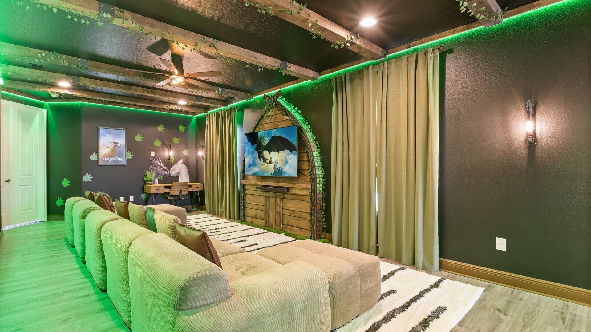 A cozy room with a green sofa, a wooden desk, and a painting on the wall.