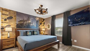 A bedroom with a large bed, a chandelier, a castle-themed wall mural, and a window with curtains. - Upstay Family Retreat w Pool, Theater & Games Room (Kissimmee)