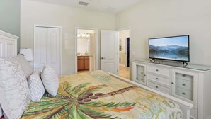 A bedroom with a bed, a TV on a dresser, and a door leading to a bathroom. - Upstay: Family Home w Pool & Cinemachampionsgate (Davenport)