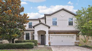 A two-story house with a garage, stone facade, and a well-maintained front yard. - Upstay: Family Home w Pool & Cinemachampionsgate (Davenport)