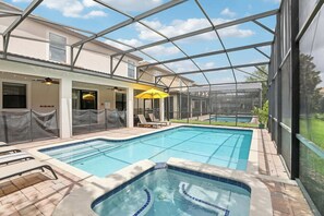 A swimming pool area with a glass-enclosed structure, lounge chairs, and a covered seating area. - Upstay: Family Home w Pool & Cinemachampionsgate (Davenport)