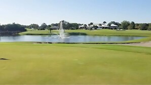 A golf course with a pond, a fountain, and a clubhouse in the background. - Upstay 2BR Golfer's Retreat w Patio Ventura Resort (Orlando)