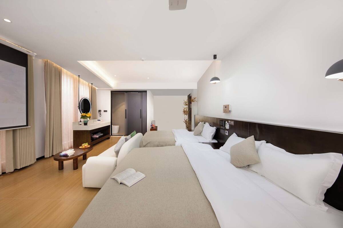 Een moderne hotelkamer met een groot bed, een flatscreen televisie, een bureau met stoel en een bank.