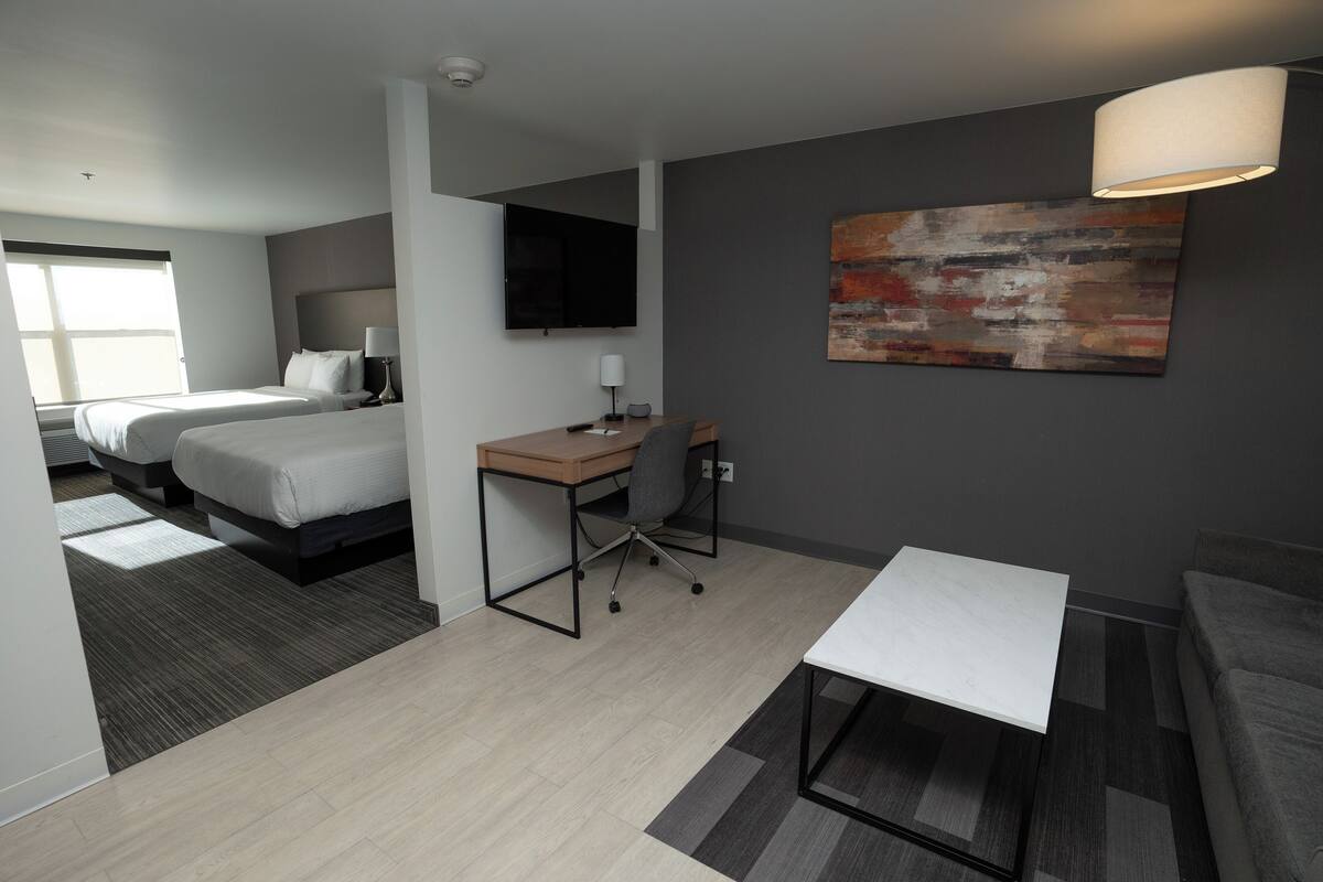 Een moderne hotelkamer met een bed, bureau en zithoek.