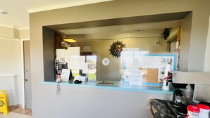 A reception desk with a counter, a telephone, various notices, and a coffee machine. - THE VICTORIAN MOTEL AND RV PARK by Capital O (Grand Forks)