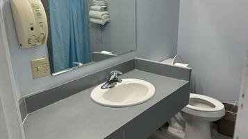Un baño con lavamanos, espejo e inodoro.