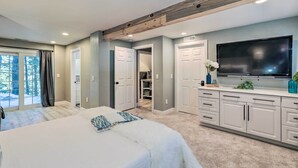 Une chambre à coucher moderne avec un grand lit, une télévision et un dressing.