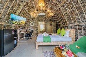 A cozy room with a bed, a desk, and a TV. - Sunshine Village Canggu (Tibubeneng)