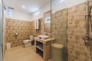 A bathroom with a toilet, sink, and shower. - Sunshine Village Canggu (Tibubeneng)