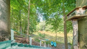 A wooden staircase leading to a covered area with two kayaks parked nearby. - Earth's River Retreat: Kayaks, Wineries and GOTL (Austinburg Township)
