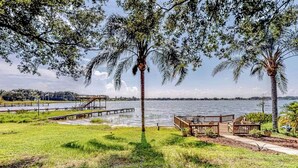 A lakeside park with a wooden deck, benches, and a gazebo.