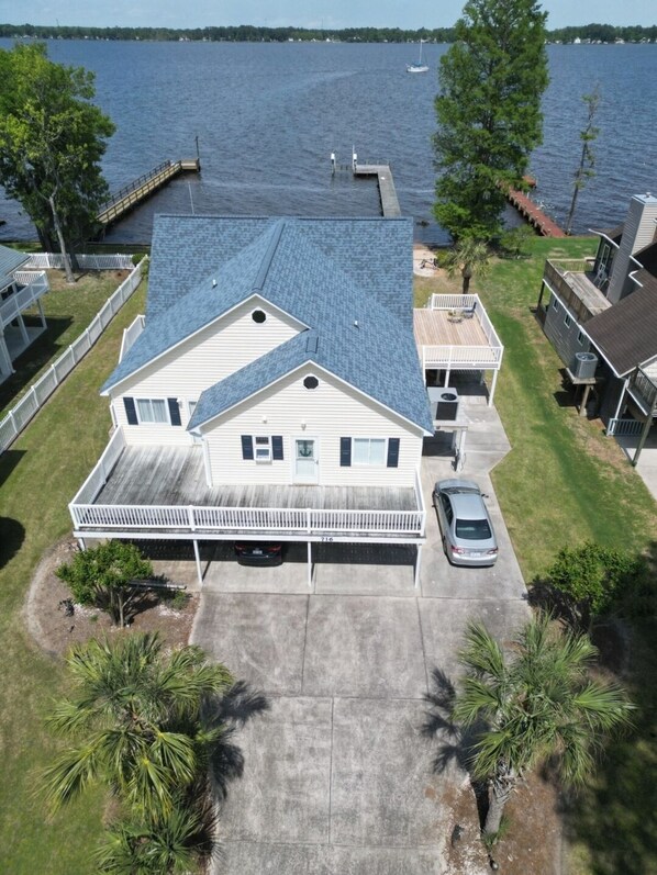 A two-story house with a covered front porch, a garage, and a driveway.