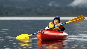 A person in a red kayak on calm water.