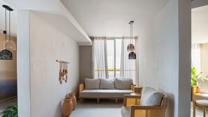 A modern living room with a sofa, wicker chairs, and hanging light fixtures. - Modern 3BR + Rooftop Pool & Jacuzzi (Cartagena de Indias)