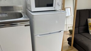 Een kleine keuken met een ingebouwde magnetron en een koelkast.
