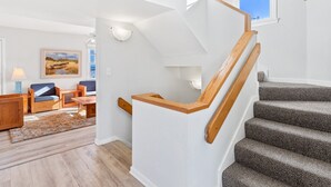 Eine Treppe mit hölzernen Geländern und Teppichstufen, die zu einer oberen Etage führt.