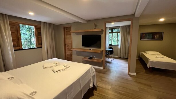 Hotellihuone, jossa on sänky, televisio, työpöytä ja tuoli.
