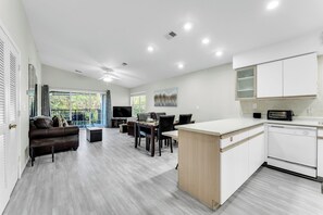 A modern apartment with a kitchen, dining area, and living room. - Branson 2BR Retreat | Jacuzzi + Gym + Pools (Branson)