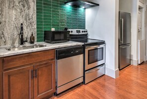 Una cocina moderna con microondas, estufa, horno y lavavajillas integrados.