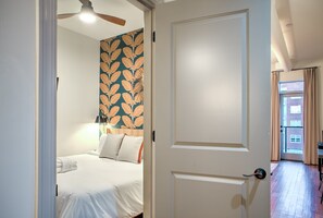 Hotelkamer met een bed, een deur, een plafondventilator en uitzicht op het buiten.