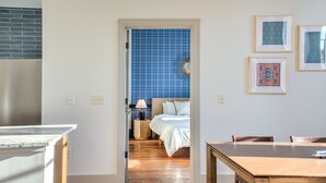 Ein Zimmer mit einem Bett, einem Holztisch und einer Wand mit blauen Fliesen.