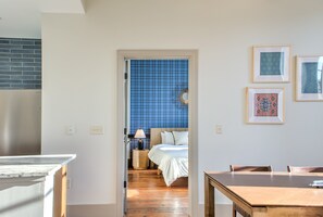 A room with a bed, a wooden table, and a blue-tiled wall. - The Sapphire at Heirloom Asheville | Downtown Asheville Historic Condo (Asheville)