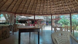 An open-air pavilion with a thatched roof, stone walls, and a tiled floor. - Trackmark Hotel Lokichogio  (Lokichogio)