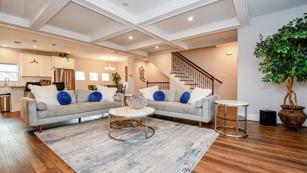 A spacious living area with a sofa set, a coffee table, and a staircase leading to an upper floor. - Modern Gated Retreat w/Rooftop Views, Med Ctr & Downtown (Houston)