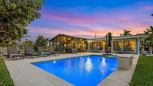 A swimming pool with lounge chairs and a covered patio area. - Operation Relaxation heated Pool & Spa, Bicycles - At Ease - Roelens (Cape Coral)