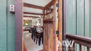 A wooden interior with a dining area, a kitchen, and a view of the outdoors. - Downtown CDA Retreat – Hot Tub, Deck, & Walk to Lake! (Coeur D Alene)