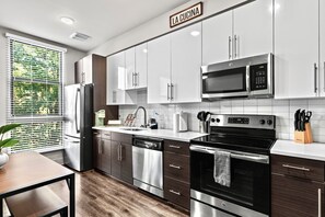 Departamento Deluxe | Cocina privada | Refrigerador con congelador, microondas, horno y parrilla de estufa 