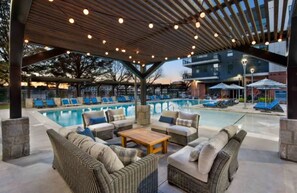 A covered outdoor area with lounge chairs and a pool. - Luxury in the skies  (Atlanta)