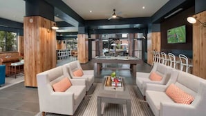 Un espace de détente moderne avec des canapés, une table de billard et un écran de télévision.