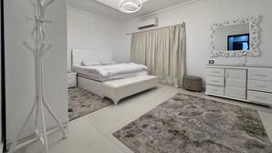 Una camera da letto moderna con un letto, comodini, una toeletta con specchio e un lampadario.