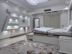 A modern bedroom with a bed, bedside tables, a mirror, and built-in shelves. - Al Sawah 6BD Villa with private pool & garden @New Cairo (New Cairo)