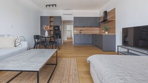 En moderne lejlighed med opholdsstue, tekøkken og spiseplads.