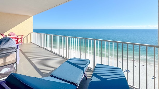 A balcony with lounge chairs and a view of the ocean. - Modern Beachfront Luxury | Balcony Grill, Gulf Views & Pool Access | BEACHBALL PROPERTIES (Gulf Shores)