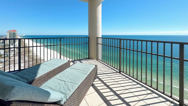 Ein Balkon mit Blick auf das Meer und ein Gebäude in der Ferne.