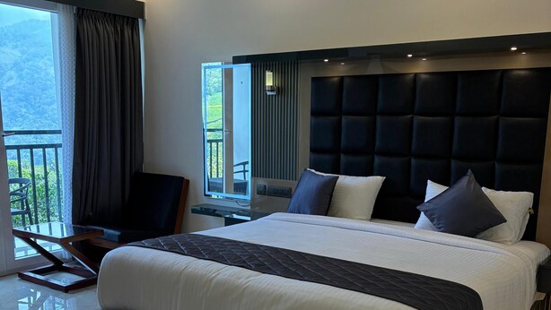 Une chambre moderne avec un grand lit, un balcon et une vue sur l’extérieur.