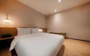 A modern hotel room with a large bed, a bedside table, a bench, and a hanging light fixture. - Hotel 23 Degrees Cheomdan (Gwangju)