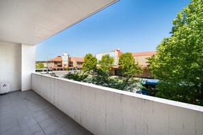 A balcony with a view of a building with a red roof and a sign that reads "WE". - Spacious 2-bed Conveniently by Lake Tuggeranong (Canberra)