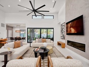 A modern living room with a sofa, coffee table, and TV. - Gemini-2 Homes-Heated Pool-Near Scottsdale Quarter (Scottsdale)