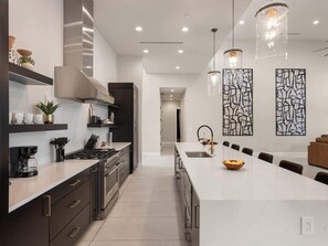A modern kitchen with a large island, stainless steel appliances, and pendant lighting. - Gemini-2 Homes-Heated Pool-Near Scottsdale Quarter (Scottsdale)