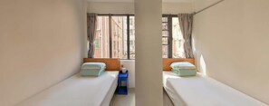 A small, narrow room with two single beds, a wooden headboard, a small blue nightstand, and a window with curtains. - Tiaohai Living Youth Hotel (Shenzhen)