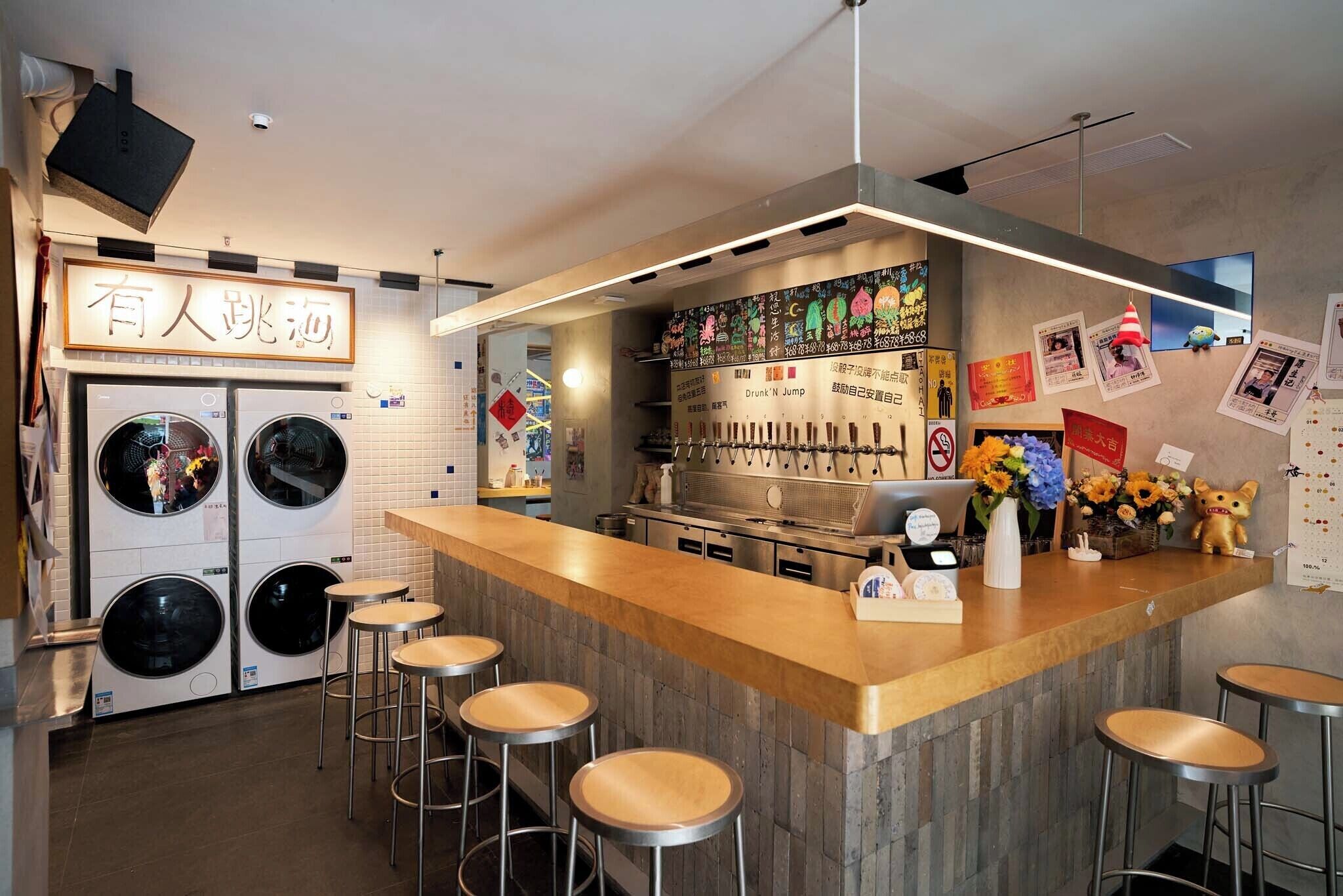 A bar area with stools, a counter, and a wall-mounted menu.