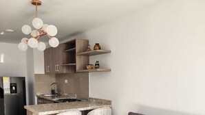 A modern kitchen with a central island, bar stools, and a built-in oven. - Spectacular Apartment in downtown Cali (Cali)