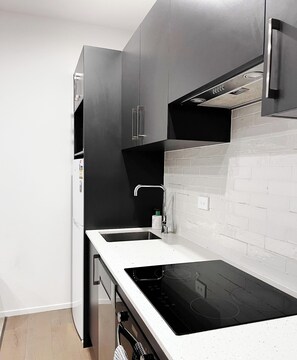 A modern kitchen with a built-in oven, a sink, and a dishwasher. - Free Parking & A/C Cooling & CBD View (Wellington)